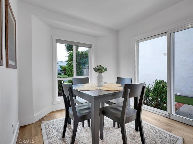 dining room featuring light wood-type flooring and baseboards