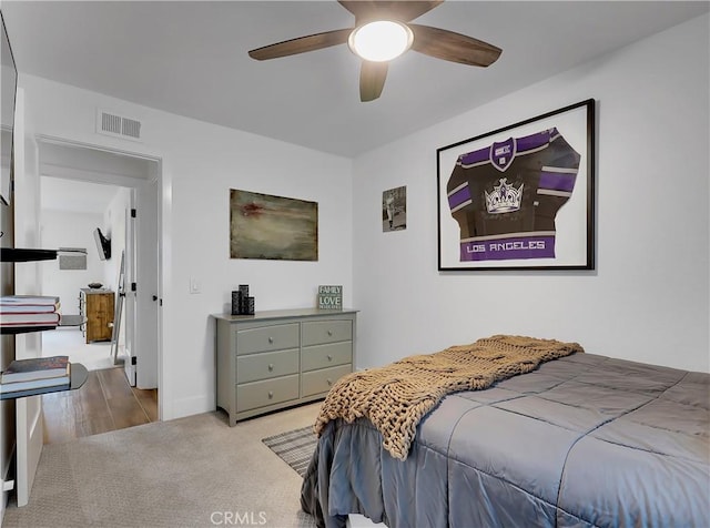 carpeted bedroom with visible vents and ceiling fan