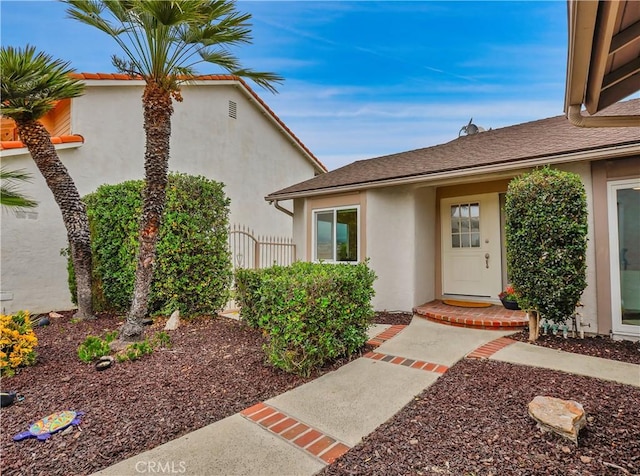 property entrance with fence and stucco siding