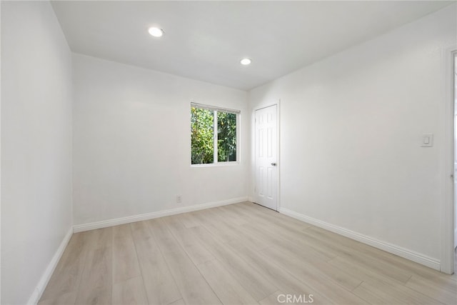 spare room with light wood-style floors, recessed lighting, and baseboards