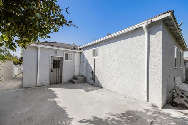 back of house with a patio, fence, and stucco siding