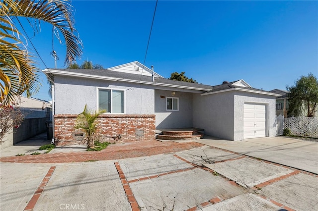 ranch-style home with a garage, fence, concrete driveway, and brick siding