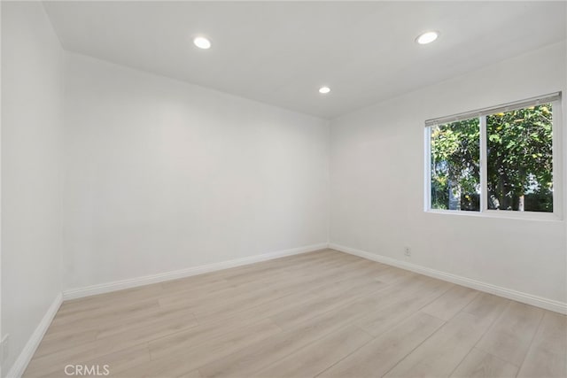 unfurnished room with light wood-style floors, baseboards, and recessed lighting