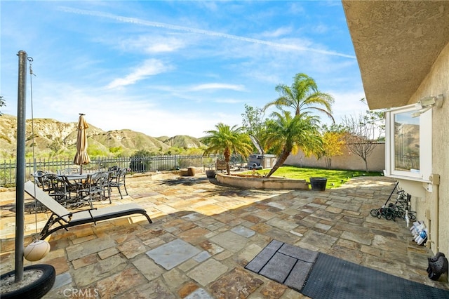 view of patio / terrace featuring outdoor dining space, a fenced backyard, and a mountain view