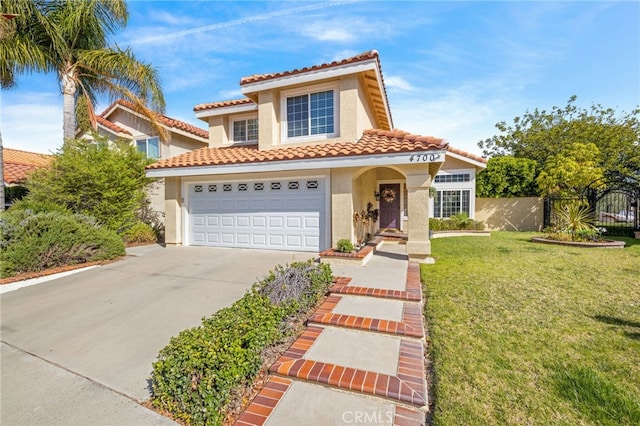 mediterranean / spanish-style home featuring stucco siding, a front lawn, a tile roof, fence, and concrete driveway