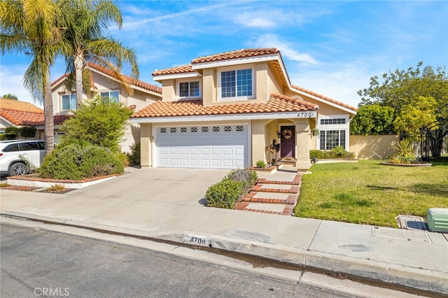 mediterranean / spanish house with a front yard, stucco siding, concrete driveway, a garage, and a tile roof