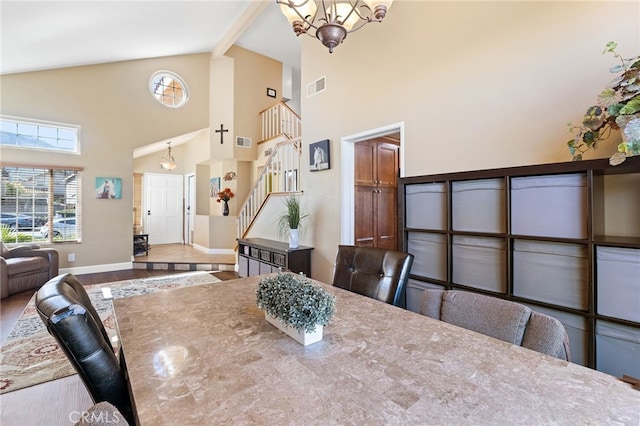 dining area with a wealth of natural light, visible vents, a notable chandelier, wood finished floors, and stairway