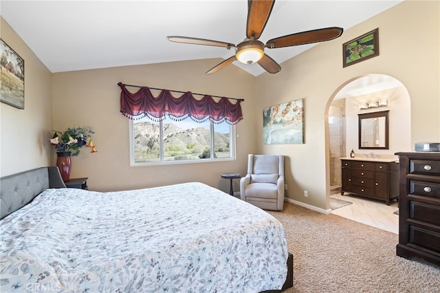 bedroom with connected bathroom, baseboards, light colored carpet, vaulted ceiling, and a ceiling fan