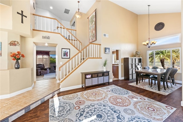 interior space featuring visible vents, wood finished floors, stairway, an inviting chandelier, and baseboards