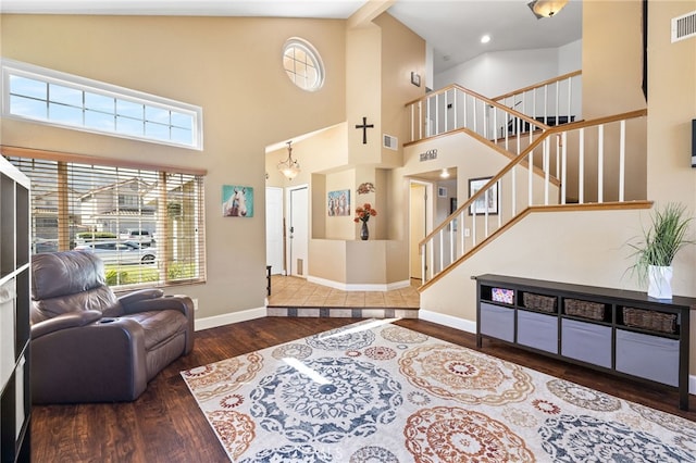 living area with visible vents, stairway, baseboards, and wood finished floors