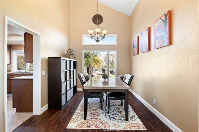 dining space with a notable chandelier, plenty of natural light, and dark wood-type flooring