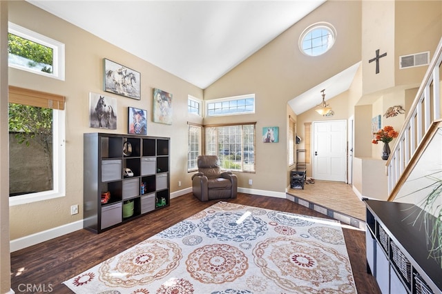 living area with visible vents, baseboards, stairs, dark wood-style floors, and high vaulted ceiling