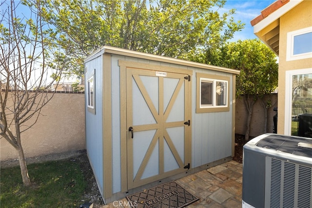 view of shed with cooling unit and a fenced backyard