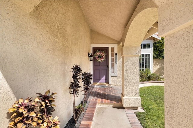 entrance to property featuring stucco siding