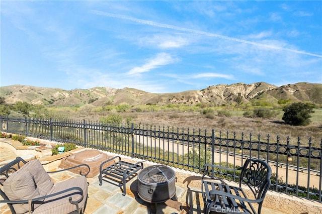 view of patio featuring a mountain view and fence