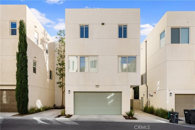 view of front of property with a garage, concrete driveway, and stucco siding