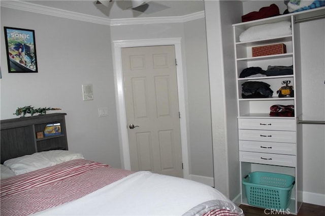 bedroom with ornamental molding, wood finished floors, and baseboards