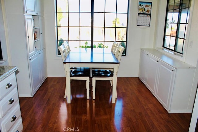 dining room with dark wood-style flooring and baseboards