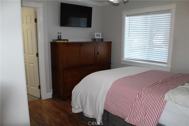 bedroom featuring wood finished floors, ornamental molding, and multiple windows
