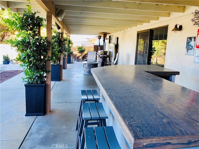 view of patio featuring outdoor dining area, fence, and outdoor dry bar