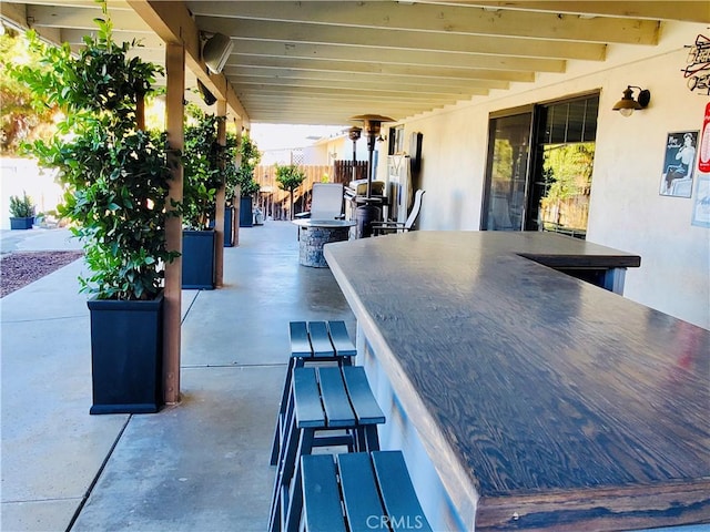 view of patio featuring fence, outdoor dry bar, and outdoor dining space