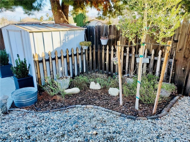 view of yard featuring a storage shed, an outdoor structure, and a fenced backyard