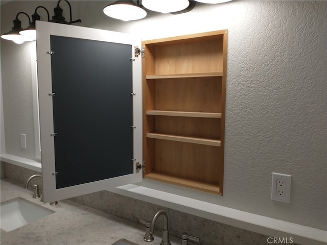 interior space featuring a textured wall and a sink