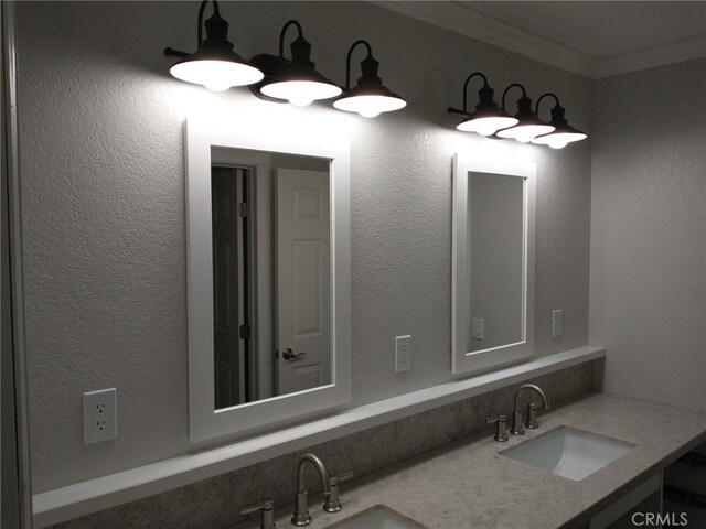 bathroom with double vanity, a sink, and ornamental molding