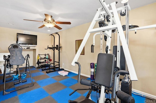 exercise area with baseboards and a ceiling fan