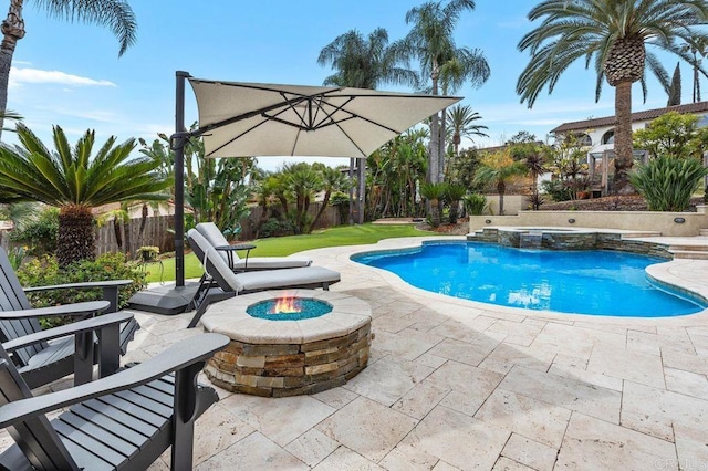 view of pool with an outdoor fire pit, a pool with connected hot tub, a fenced backyard, and a patio