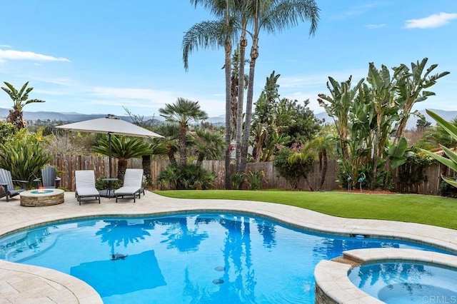 view of pool with a patio area, a fenced backyard, a fire pit, and a lawn