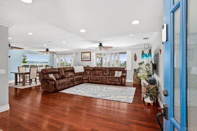 living room with ornamental molding, baseboards, and wood finished floors