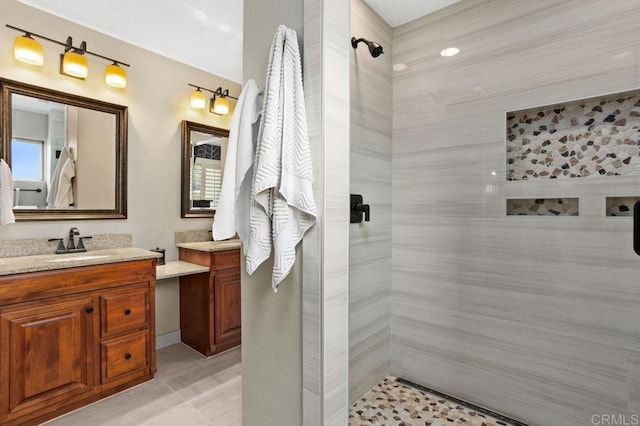 bathroom with tiled shower and vanity