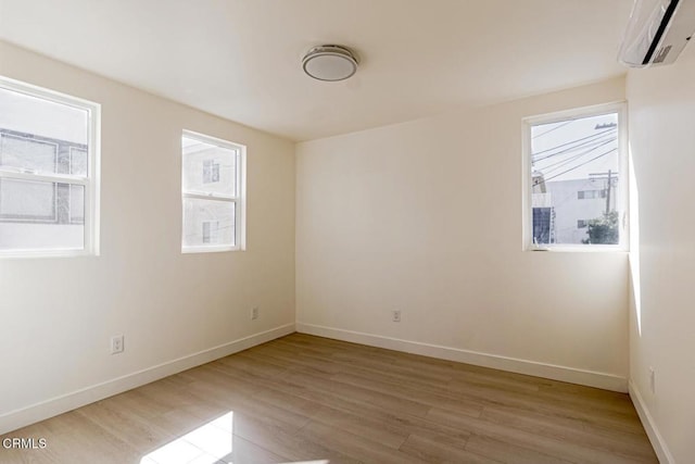 741 S Curson Ave, Los Angeles, CA 90036 - unfurnished room featuring baseboards, a wall unit AC, and light wood-style floors