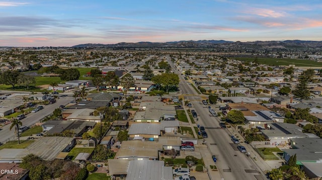 aerial view at dusk featuring a residential view and a mountain view