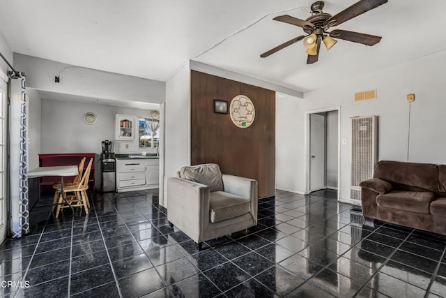 living room with visible vents, granite finish floor, and ceiling fan