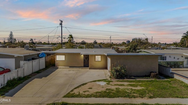 view of front facade with fence and stucco siding