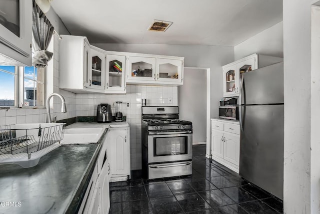 kitchen with appliances with stainless steel finishes, a sink, visible vents, and white cabinetry