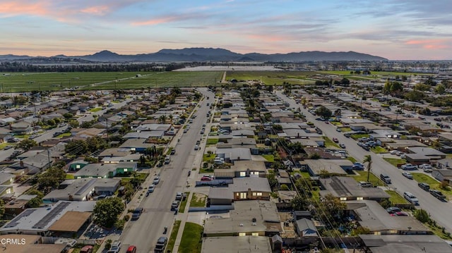 aerial view at dusk featuring a residential view and a mountain view