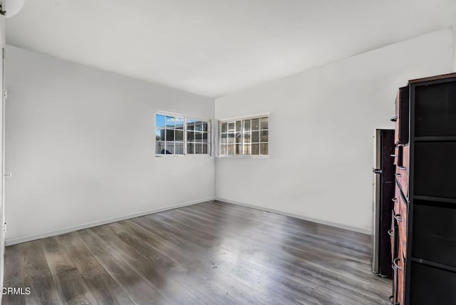 spare room featuring wood finished floors and baseboards