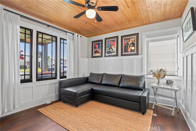 living room featuring a ceiling fan, wood ceiling, a decorative wall, and wood finished floors