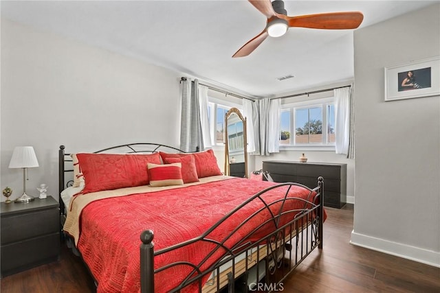 bedroom featuring a ceiling fan, wood finished floors, visible vents, and baseboards