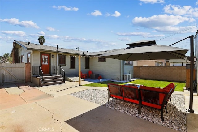 back of house with a gate, a patio area, fence, and an outdoor living space