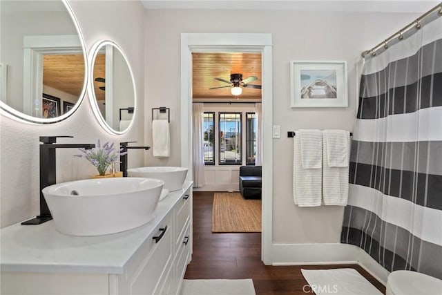 bathroom with double vanity, a ceiling fan, a sink, and wood finished floors