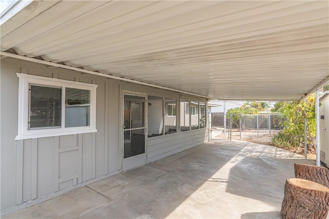 view of patio featuring a gate, fence, and an attached carport