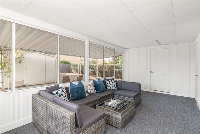 interior space with expansive windows, a drop ceiling, and carpet