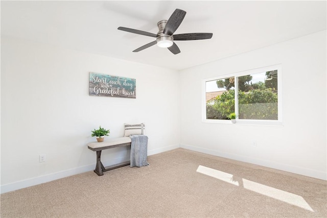 empty room with a ceiling fan, light colored carpet, and baseboards