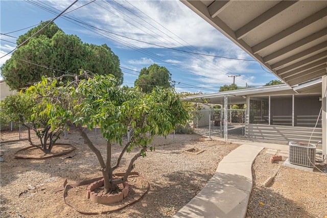 view of yard with cooling unit, a sunroom, and fence