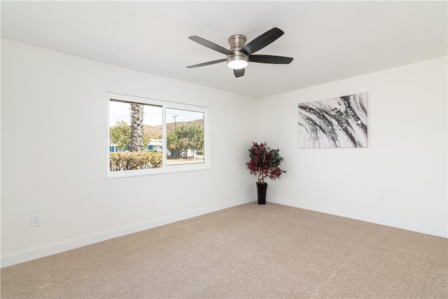 empty room featuring ceiling fan, carpet floors, and baseboards