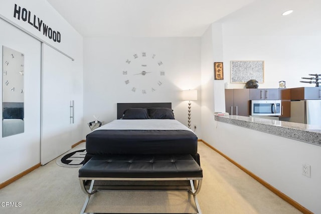 bedroom with recessed lighting, a closet, light colored carpet, freestanding refrigerator, and baseboards